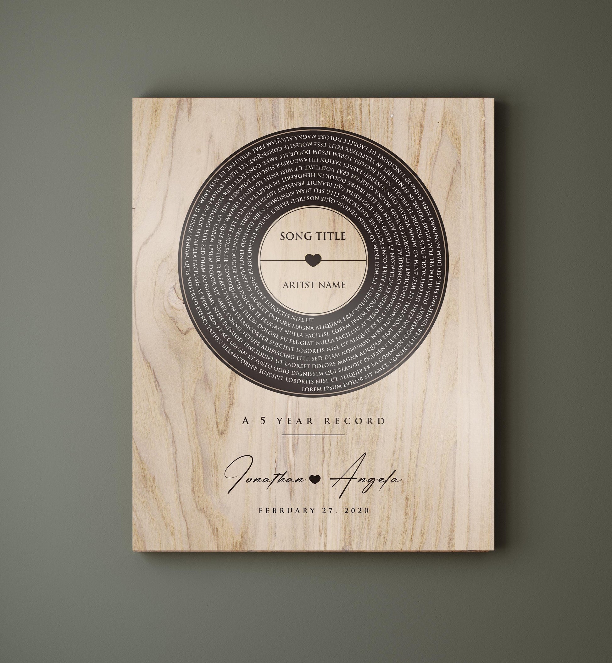 This is a photo of a 5th wedding anniversary, Our 5 Year Record wall plaque is a wood plaque - The record design pops in a deep coffee tone set against a natural polished birch - featuring song lyrics of choice in a vinyl record motif, accented with the couple's names with a heart symbol between then and the couples wedding date