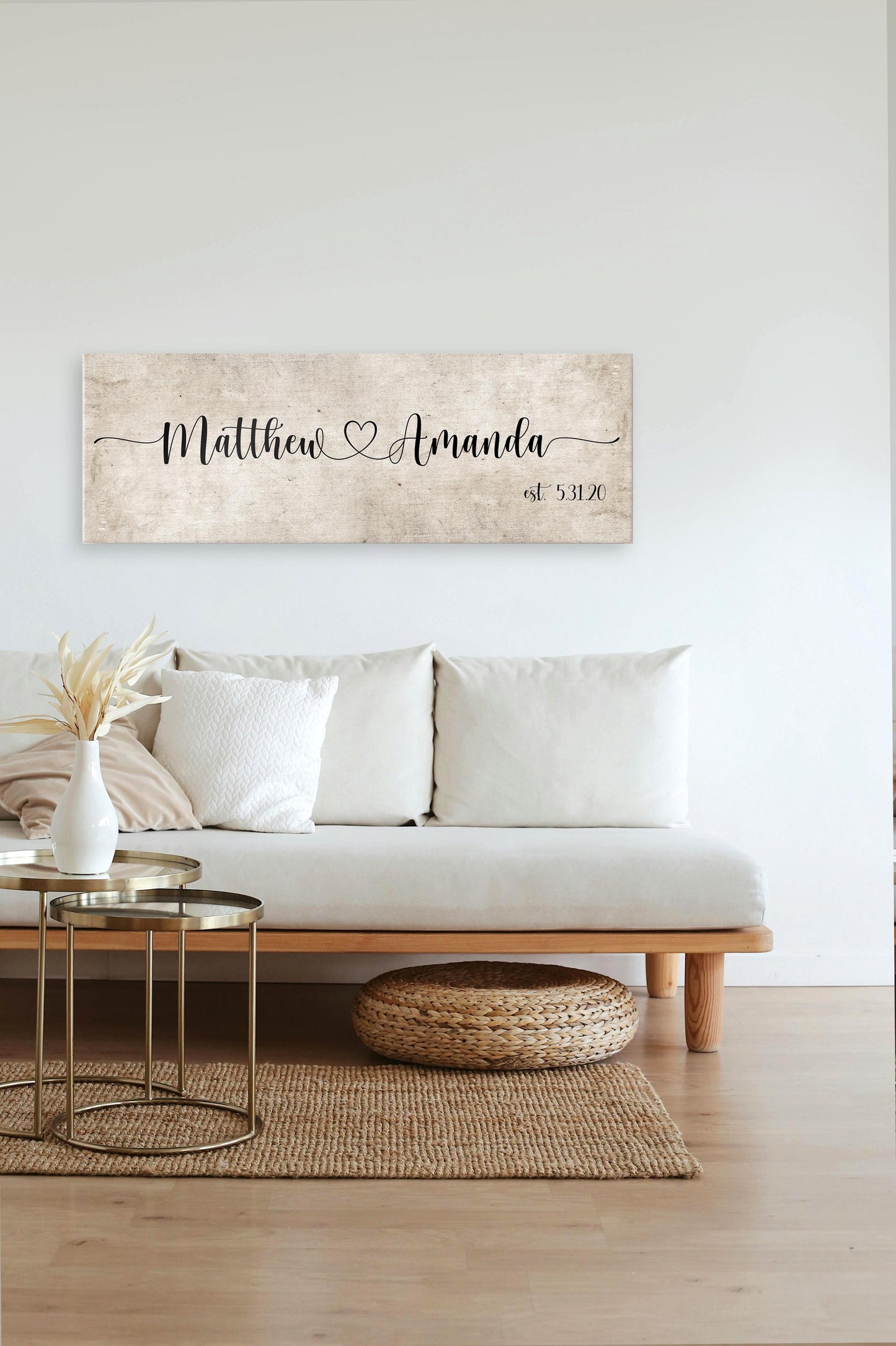 rustic cotton canvas name sign, with 2 first names connected by a heart in a whimsical and playful typeface. A personalized name sign on vintage cotton hangs on wall above bench in entry of home.