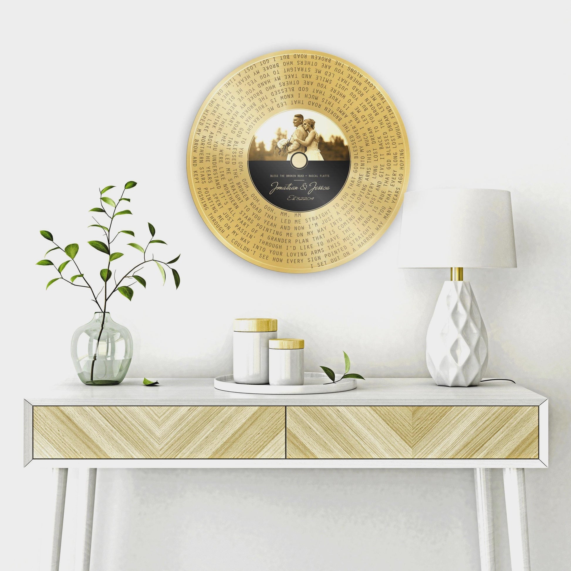 Custom Brass Anniversary Song Record Plaque hangs on a wall above a table. The record label is customized with a portrait and the song title, artist name and the couple's names and union date.

Courtesy of Honeycomb Proverbs
