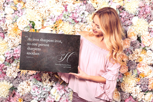 Attractive blonde woman holding a custom metal plaque with the verse, "as iron sharpens iron, so one person sharpens another", from Proverbs 27:17. The plaque is personalized with the monogram H and the names Sarah and Richard Haley and a union date.

Photo courtesy of Honeycomb Proverbs