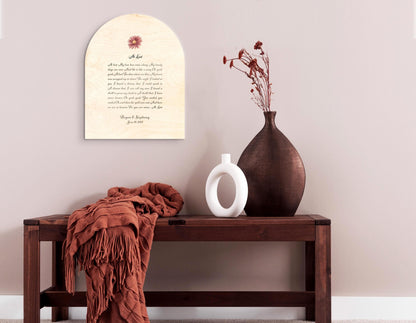 Custom lyrics song plaque in an arch shaped on natural pine, features a blush colored daisy flower motif seated above the song title "At Last" with the lyrics beneath. The plaque is finished with the names and wedding date of the recipient of this couple's plaque. The inscription is an elegant yet easily readable calligraphy script in deep coffee.