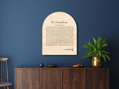 Arched wood christian wall decor, with The Ten Commandments scripted in a rustic typeface, and Exodus 20 verses in a paragraph. Personalized with a family last name serves as a name sign and bible verse art. Wood tones are natural birch with defined wood grain.